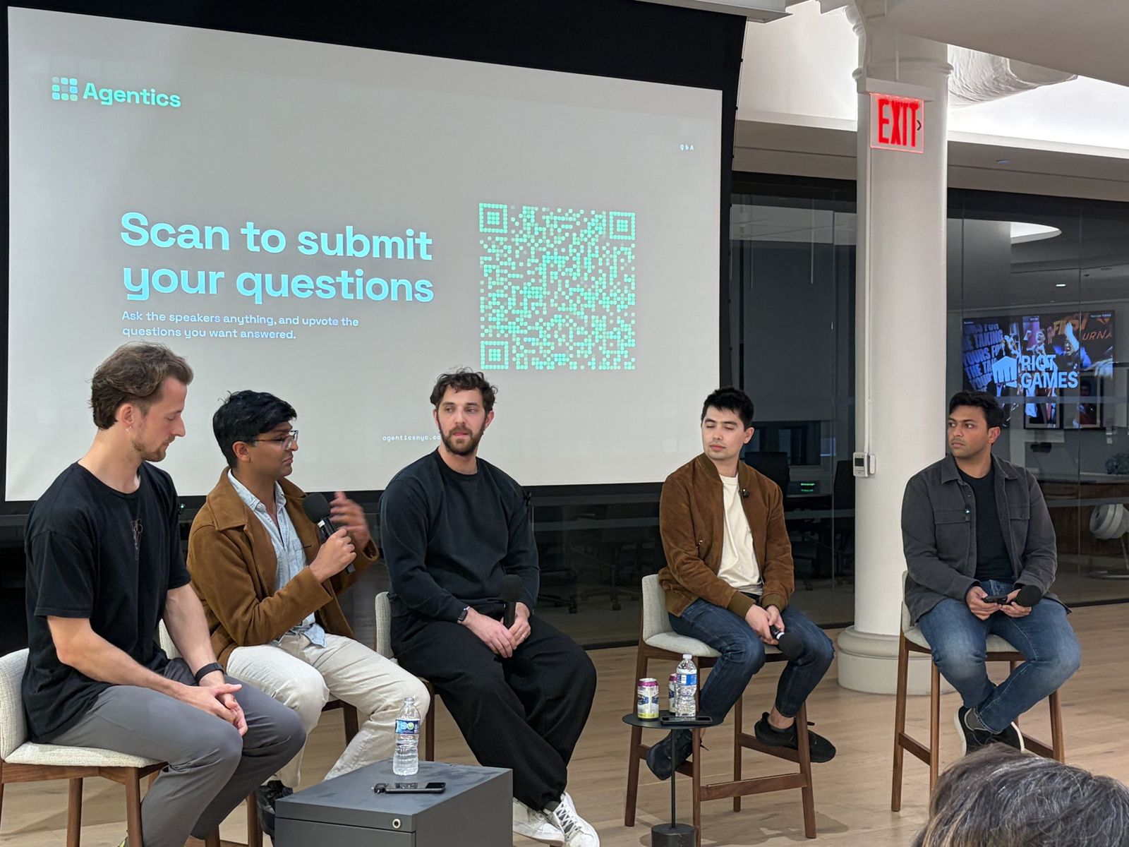 A panelist speaking with the question-submission QR code on screen